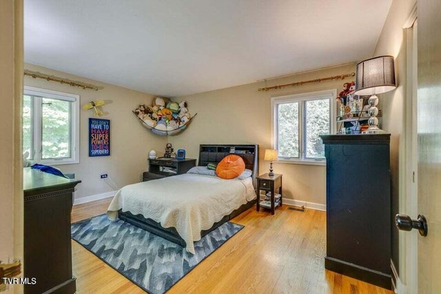 bedroom with light wood-type flooring and baseboards