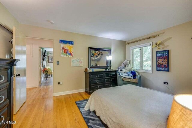 bedroom featuring baseboards and light wood finished floors