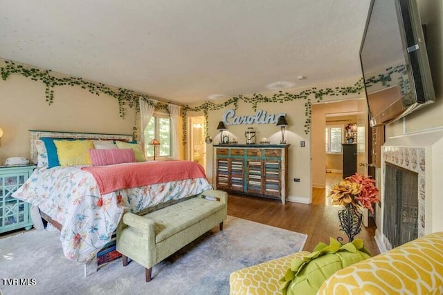 bedroom featuring wood finished floors and a fireplace