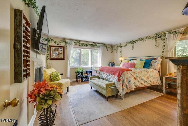 bedroom featuring a fireplace and wood finished floors