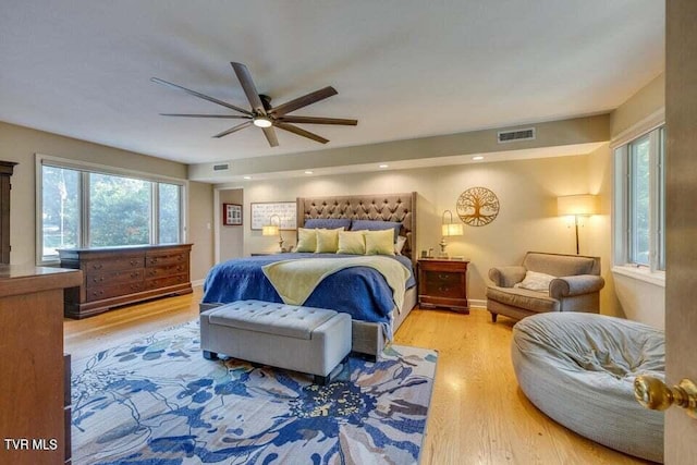 bedroom featuring ceiling fan, visible vents, baseboards, and wood finished floors