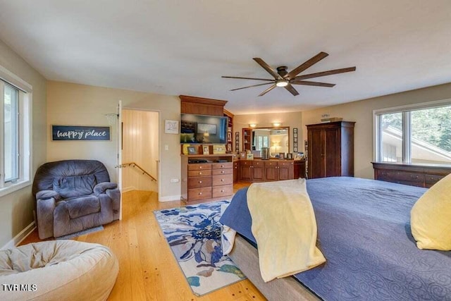 bedroom with ceiling fan, baseboards, and light wood-style floors