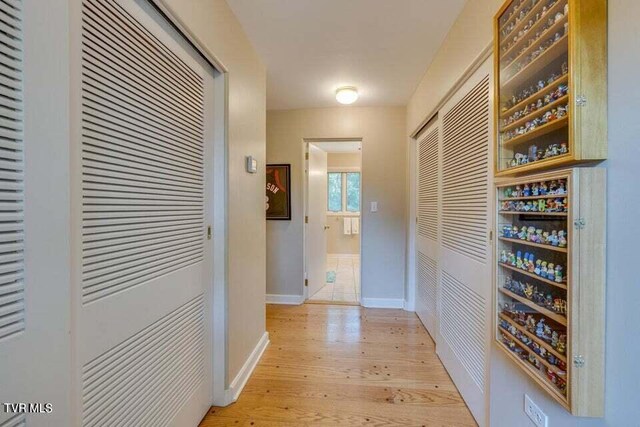 hall featuring baseboards and light wood-style floors