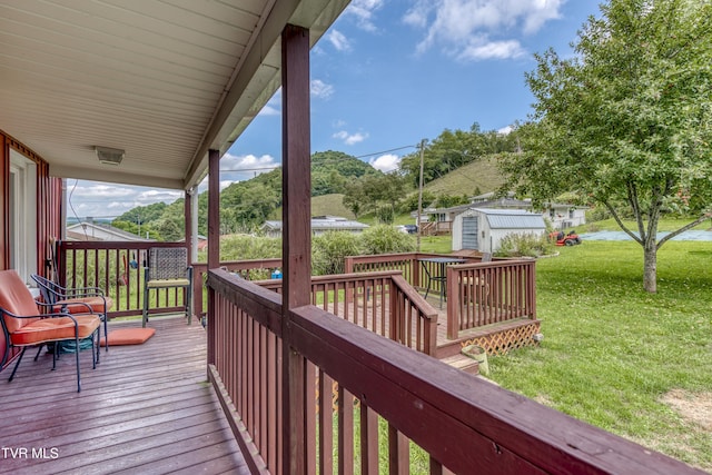 deck with a shed, an outbuilding, and a yard