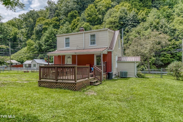 rear view of property with a fenced backyard, metal roof, and a lawn