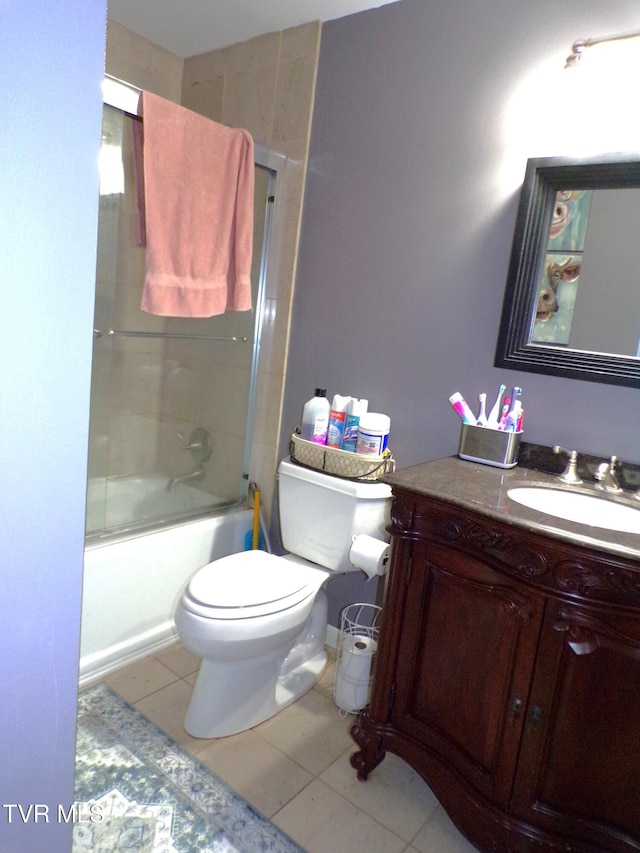 full bath featuring tile patterned flooring, toilet, vanity, and shower / bath combination with glass door