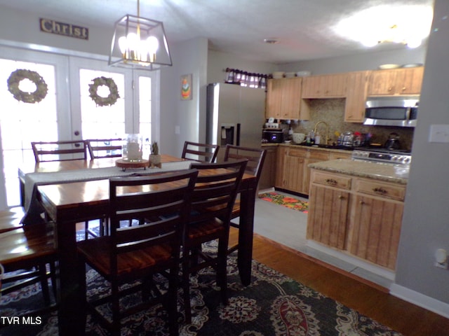 dining room featuring a chandelier, french doors, and light wood-style floors