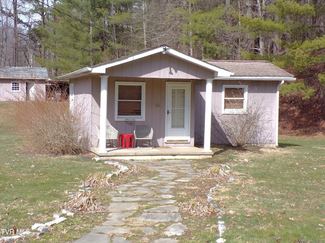 view of front facade with a front lawn and roof with shingles