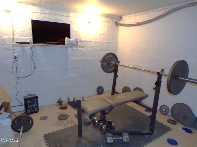 exercise room featuring concrete block wall