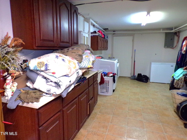 laundry room with electric panel, light tile patterned flooring, and washer and dryer