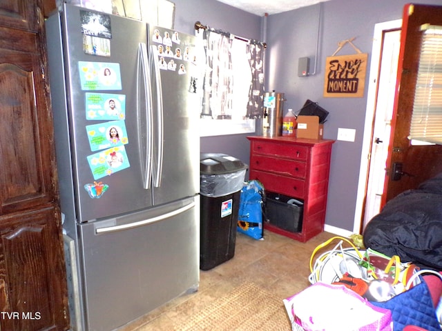 bedroom with light tile patterned flooring and freestanding refrigerator