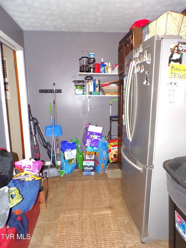 laundry area featuring tile patterned floors and a textured ceiling