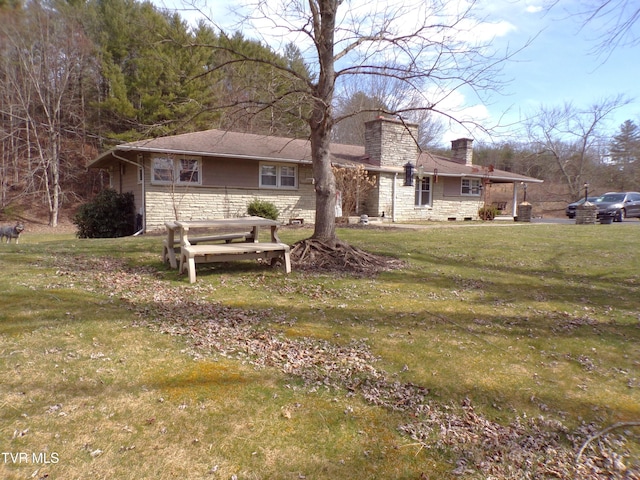 rear view of property featuring stone siding, a chimney, and a yard