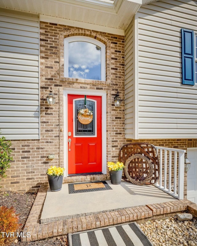 property entrance featuring brick siding