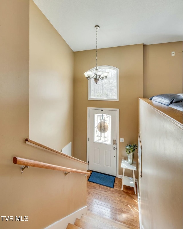 entryway featuring light wood finished floors, a chandelier, and visible vents