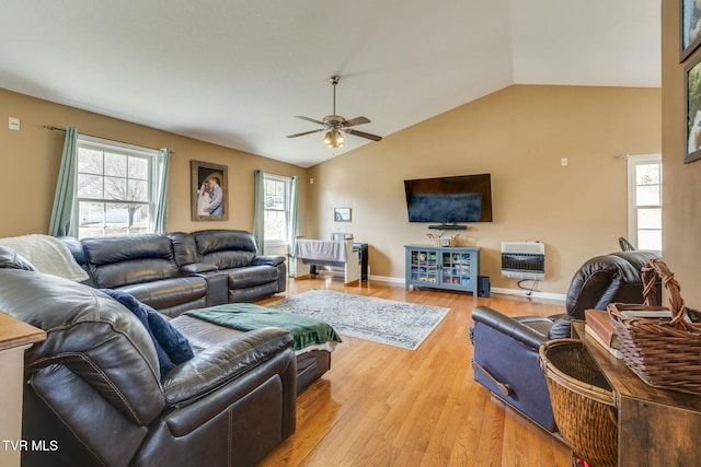 living area featuring heating unit, a ceiling fan, baseboards, lofted ceiling, and light wood-type flooring