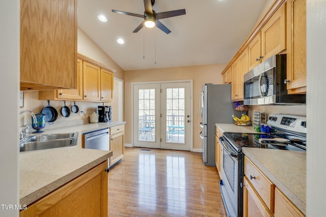 kitchen featuring appliances with stainless steel finishes, light countertops, light wood-style floors, and a sink