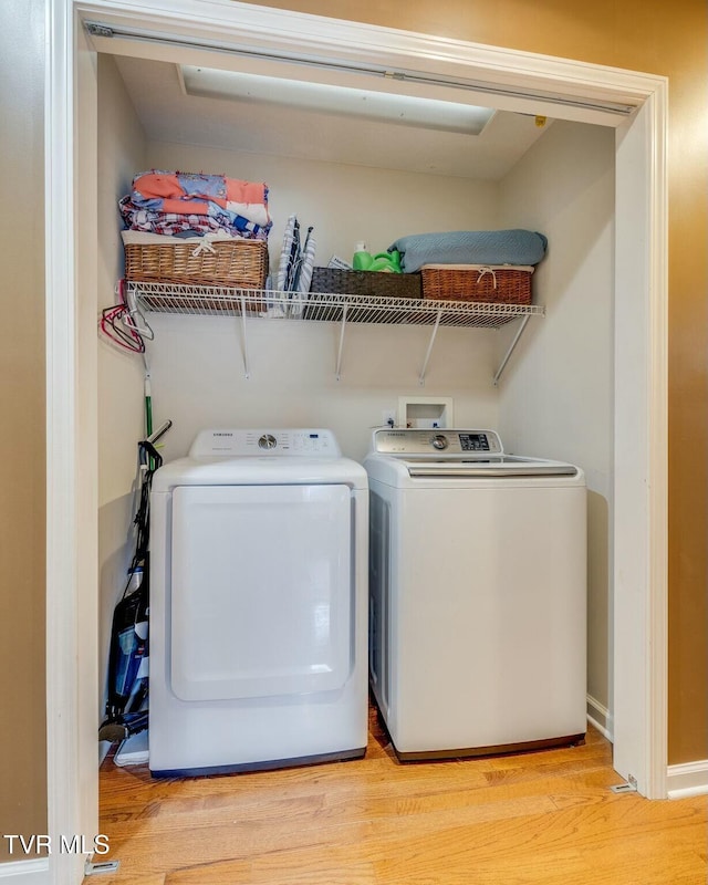 laundry area featuring laundry area, wood finished floors, and independent washer and dryer