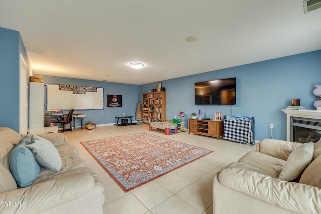 living room featuring tile patterned flooring, visible vents, and a fireplace