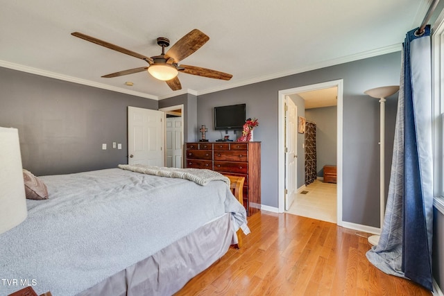 bedroom featuring ceiling fan, baseboards, light wood-type flooring, ornamental molding, and ensuite bath