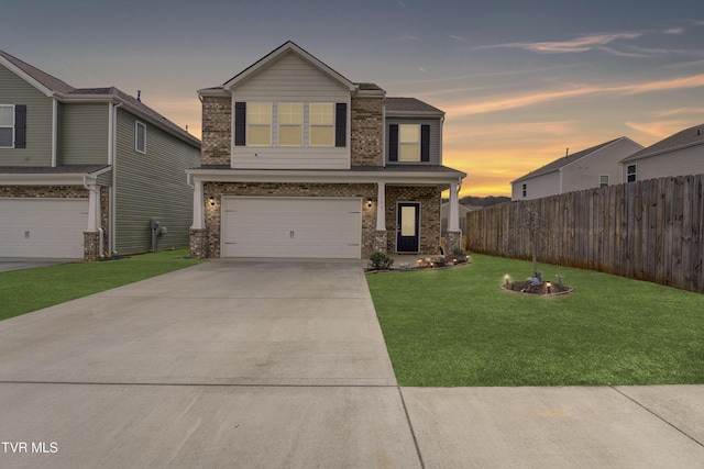 view of front of home with a front lawn, fence, brick siding, and driveway