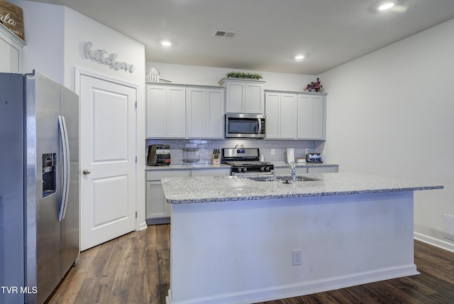 kitchen with visible vents, a sink, dark wood-style floors, appliances with stainless steel finishes, and decorative backsplash