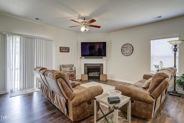 living area featuring visible vents, a fireplace with flush hearth, baseboards, and dark wood-style floors