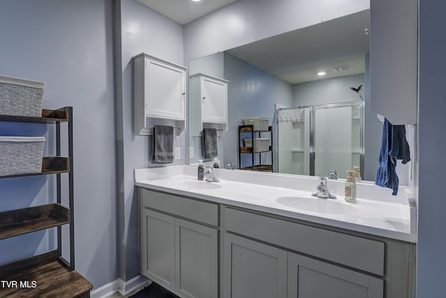 full bathroom featuring a sink, visible vents, double vanity, and a shower stall