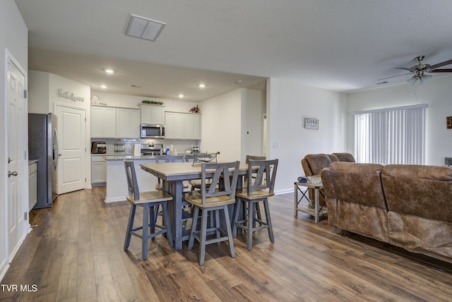 dining space featuring visible vents, dark wood finished floors, recessed lighting, baseboards, and ceiling fan