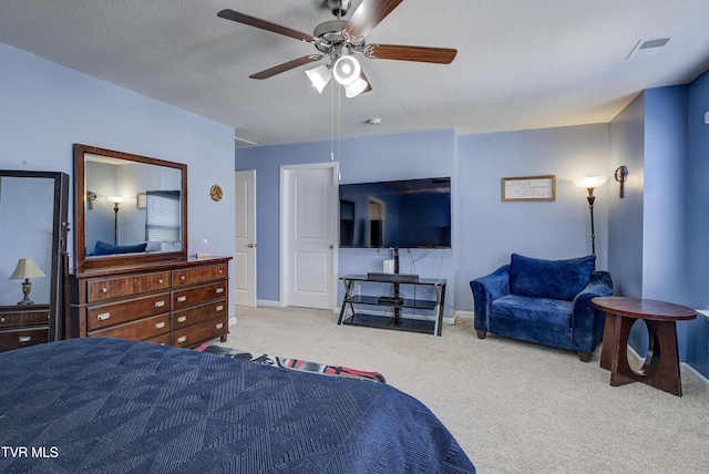 carpeted bedroom with baseboards, visible vents, a textured ceiling, and ceiling fan