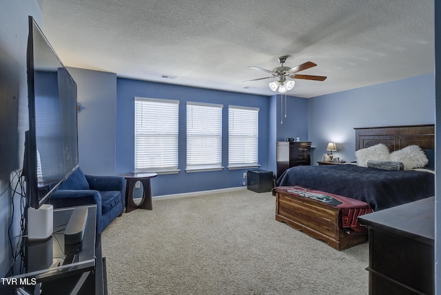 carpeted bedroom with visible vents, baseboards, a textured ceiling, and a ceiling fan