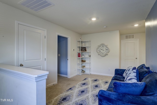 sitting room featuring light colored carpet, visible vents, and baseboards