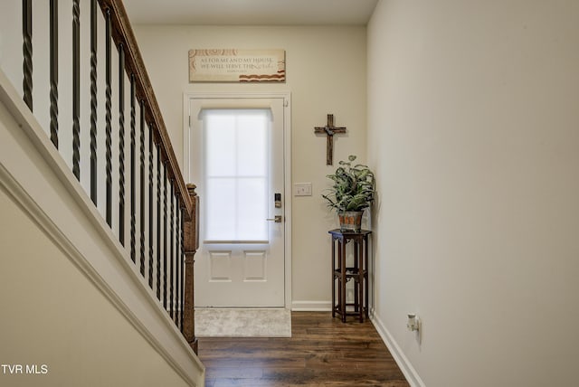 foyer entrance with baseboards, dark wood finished floors, and stairs