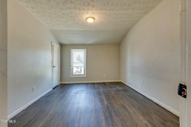 unfurnished room with a textured ceiling, dark wood-type flooring, and baseboards