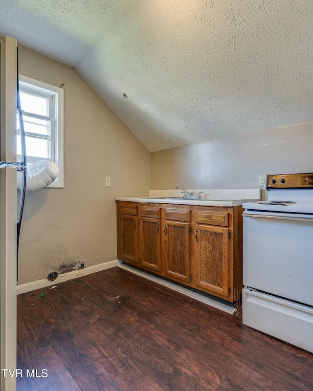 kitchen with brown cabinets, electric stove, a textured ceiling, dark wood-style floors, and lofted ceiling