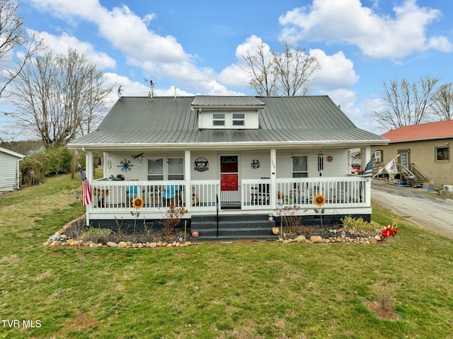 view of front facade with metal roof, covered porch, and a front lawn