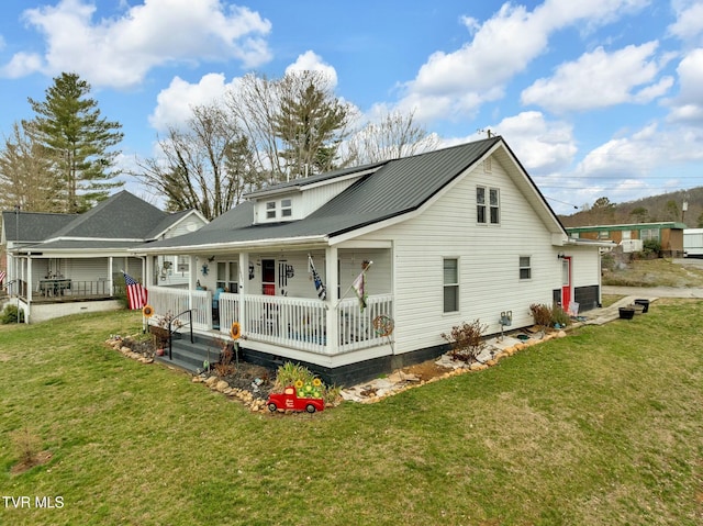 rear view of house featuring a lawn and a porch