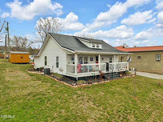 exterior space featuring metal roof, covered porch, and a front yard