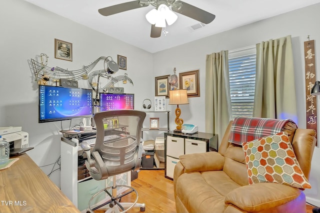 office area with a ceiling fan, wood finished floors, and visible vents