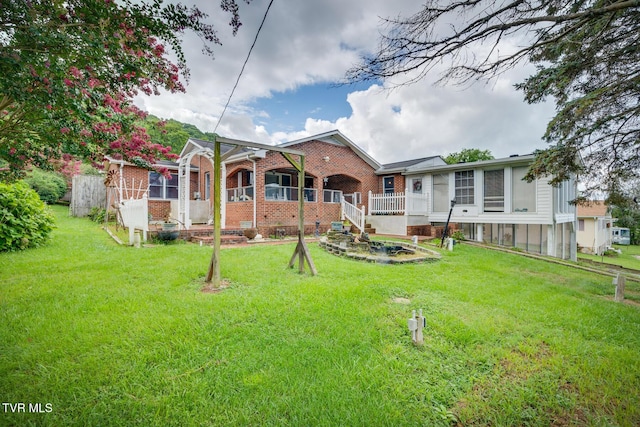 back of house with a lawn and brick siding