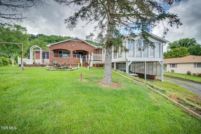 view of front of house featuring brick siding, driveway, and a front lawn