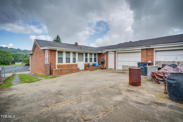 ranch-style house featuring brick siding, an attached garage, and concrete driveway