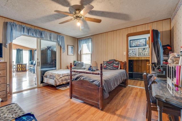 bedroom with light wood finished floors, multiple windows, a textured ceiling, and ceiling fan