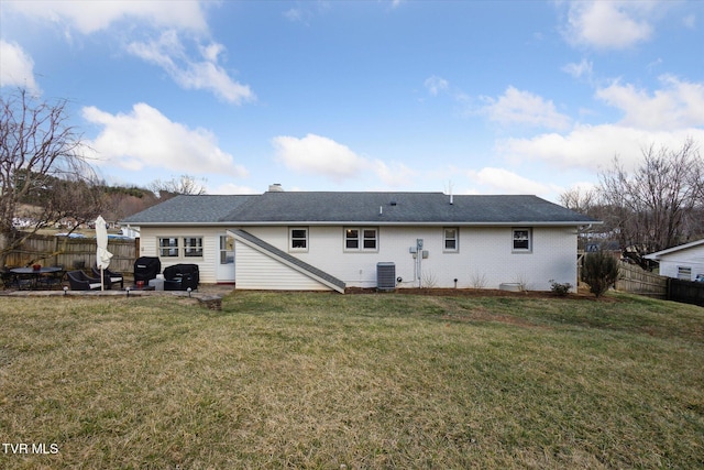 back of house featuring a yard, central AC unit, and a fenced backyard