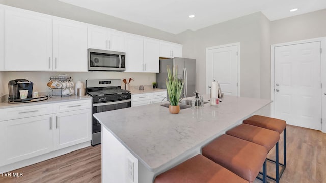 1807 Fox Meadows Cir, Bluff City, TN 37618 - kitchen featuring appliances with stainless steel finishes, a sink, light wood finished floors, a kitchen island with sink, and recessed lighting