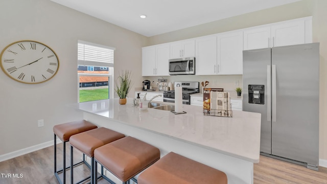 1807 Fox Meadows Cir, Bluff City, TN 37618 - kitchen featuring stainless steel appliances, a sink, light wood-type flooring, white cabinets, and baseboards