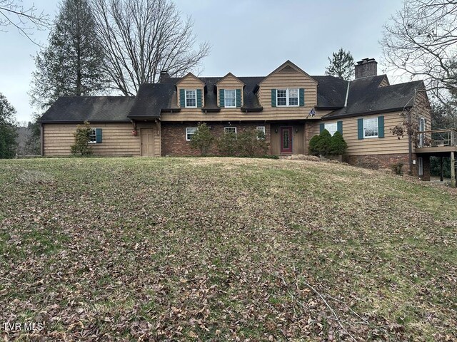 view of front of home with a front yard and a chimney