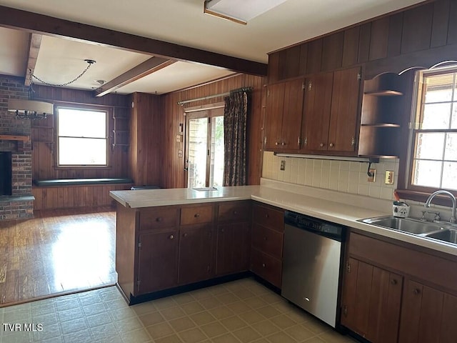 kitchen with open shelves, beam ceiling, a sink, stainless steel dishwasher, and a wealth of natural light