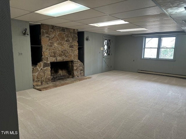 basement featuring a drop ceiling, a baseboard heating unit, carpet floors, and a fireplace