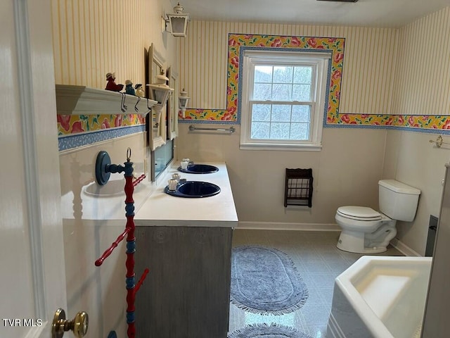 bathroom with vanity, toilet, and baseboards